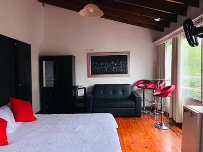 a bedroom with a bed and a couch and a chair at Hotel Lleras Premium #1 in Medellín
