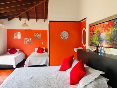 a bedroom with two beds and an orange wall at Hotel Lleras Premium #1 in Medellín