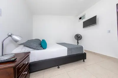 a bedroom with a bed and a desk and a lamp at Hotel Ayenda Palo Alto in Medellín