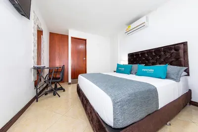 a bedroom with a bed and a desk in a room at Hotel Ayenda Palo Alto in Medellín