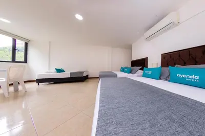 a large room with two beds and a couch at Hotel Ayenda Palo Alto in Medellín
