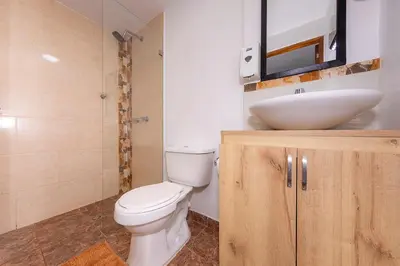 a bathroom with a white toilet and a sink at Hotel Ayenda Palo Alto in Medellín