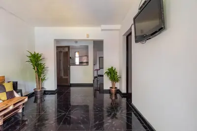a living room with a flat screen tv and plants at CAMPO VALDES PARK HOSTEL in Medellín