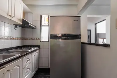 a kitchen with a stainless steel refrigerator at CAMPO VALDES PARK HOSTEL in Medellín