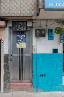 a door of a building with a sign on it at CAMPO VALDES PARK HOSTEL in Medellín