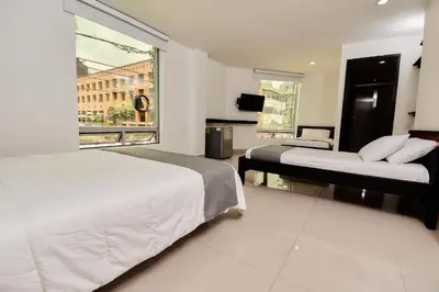 a bedroom with two beds and a large window at Tik by Bernalo Hotels in Medellín