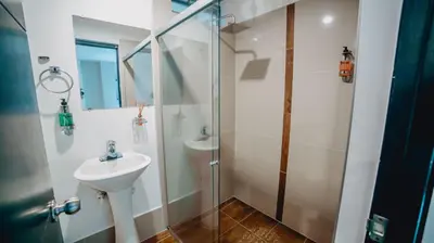 a bathroom with a sink and a glass shower at Tik by Bernalo Hotels in Medellín