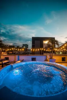 a hot tub on the roof of a building at night at Tik by Bernalo Hotels in Medellín