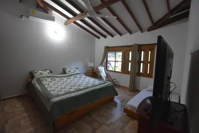 a bedroom with a bed and a flat screen tv at Villa Ilusion 88 in Puerto Boyacá