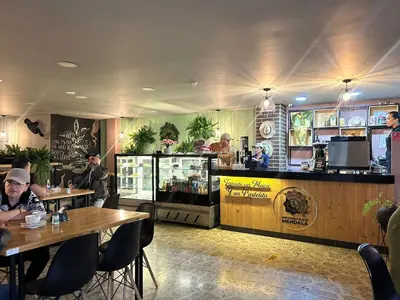 a restaurant with people sitting at tables and a bar at Mandala Medellín Centro By GyC Hotels in Medellín