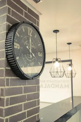 a clock on the side of a brick wall at Mandala Medellín Centro By GyC Hotels in Medellín