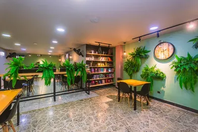 a restaurant with plants on the walls and tables at Mandala Medellín Centro By GyC Hotels in Medellín