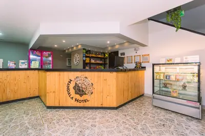 a restaurant with a counter and a refrigerator at Mandala Medellín Centro By GyC Hotels in Medellín
