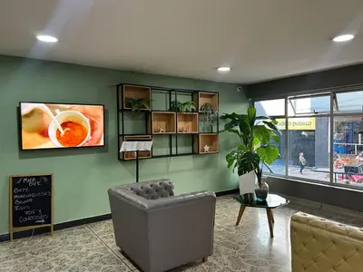 a living room with a chair and a table at Mandala Medellín Centro By GyC Hotels in Medellín