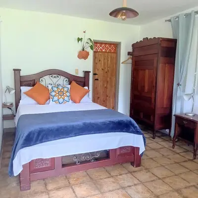 a bedroom with a large bed and a dresser at Alojamiento Rural Jardín Consentido in Jardin