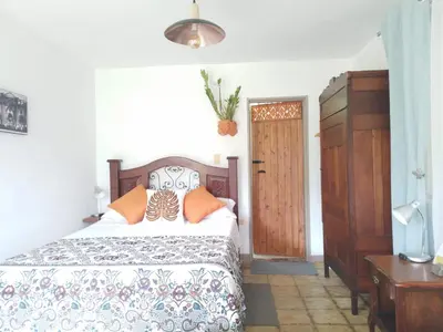 a bedroom with a bed and a wooden door at Alojamiento Rural Jardín Consentido in Jardin