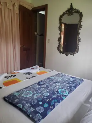 a bed with a blanket on it with a mirror at Rosita 3 in Jardin