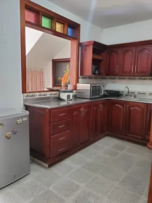 a kitchen with wooden cabinets and a large window at Rosita 3 in Jardin