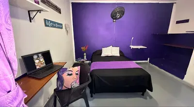 a room with a bed and a desk with a laptop at Casa Egos Pop Laureles in Medellín