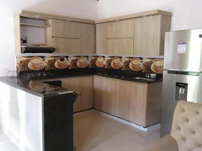 a kitchen with wooden cabinets and a counter with a refrigerator at Villa del Socorro in Jardin