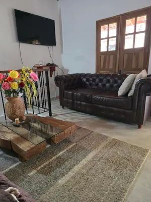 a living room with a leather couch and a coffee table at Villa del Socorro in Jardin