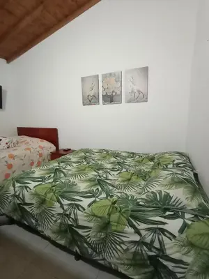 a bedroom with a bed and three pictures on the wall at Villa del Socorro in Jardin