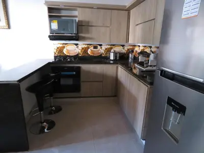 a kitchen with wooden cabinets and a black counter top at Villa del Socorro in Jardin