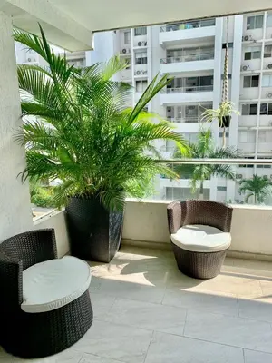 a balcony with two chairs and a table and a plant at Hermoso Apartasol San Jeronimo in San Jerónimo