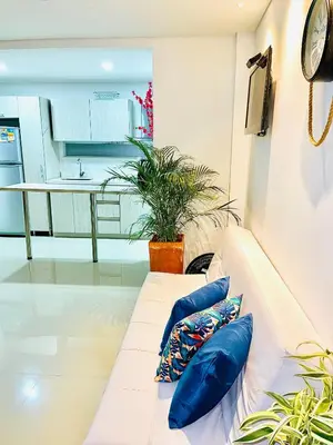 a white couch with blue pillows in a living room at Hermoso Apartasol San Jeronimo in San Jerónimo