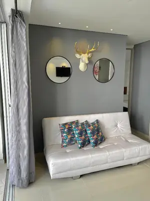 a living room with a white couch with pillows and mirrors at Hermoso Apartasol San Jeronimo in San Jerónimo