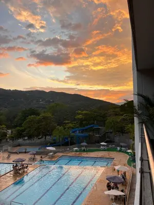 a view of a swimming pool at sunset at Hermoso Apartasol San Jeronimo in San Jerónimo