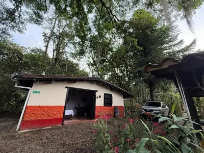 a small house with a car parked in front of it at Compostela cabaña privada (private cabin for rent) in Jardin