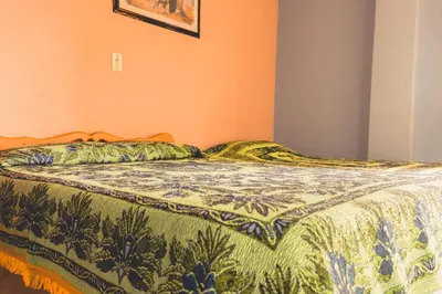 a bed in a bedroom with a blanket on it at Hotel Felicina in Jericó