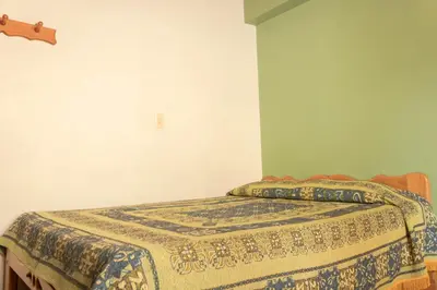 a bedroom with a bed with a blanket on it at Hotel Felicina in Jericó
