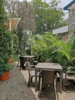 an outdoor patio with tables and chairs and plants at Cloud9 Hostel in Medellín