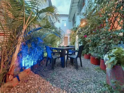 a table and chairs in a garden with plants at Cloud9 Hostel in Medellín