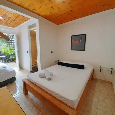 a bedroom with a large bed with a wooden ceiling at Cloud9 Hostel in Medellín