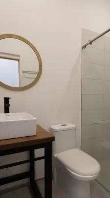 a bathroom with a toilet and a sink and a mirror at Soy Local Primavera in Medellín