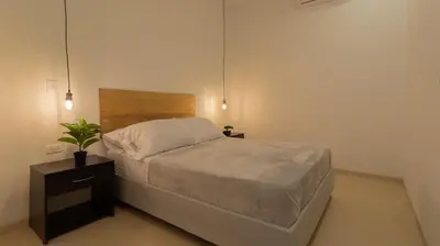 a bedroom with a bed with a wooden head board at Soy Local Primavera in Medellín