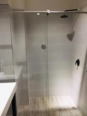 a shower with a glass door in a bathroom at Soy Local Primavera in Medellín