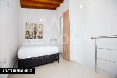 a bedroom with a bed in a white room at NevadaLofts in Sabaneta