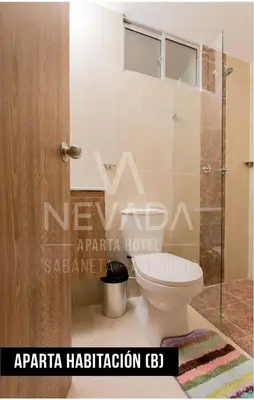 a bathroom with a toilet and a glass door at NevadaLofts in Sabaneta
