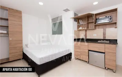 a bedroom with a bed and a kitchen in a room at NevadaLofts in Sabaneta