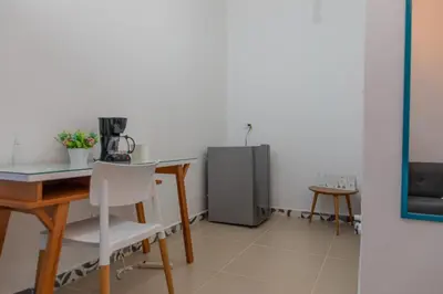 a dining room with a table and a refrigerator at Hotel Azulado Jericó in Jericó