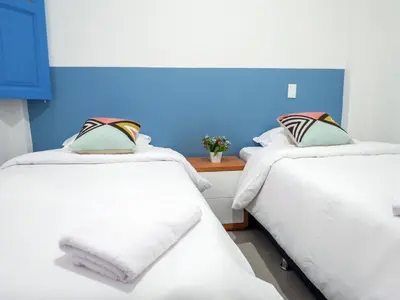 two beds in a room with a blue wall at Hotel Azulado Jericó in Jericó