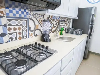 a kitchen with a stove top oven next to a sink at Hotel Azulado Jericó in Jericó