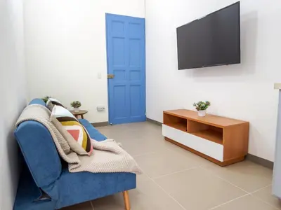 a living room with a blue chair and a tv at Hotel Azulado Jericó in Jericó