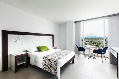 a bedroom with a bed and a table and chairs at Hotel Santorini in Guatapé