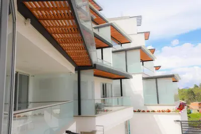 an external view of a house with glass balconies at Hotel Santorini in Guatapé