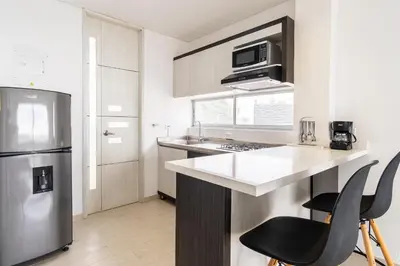 a kitchen with a stainless steel refrigerator and a counter at Hotel Santorini in Guatapé